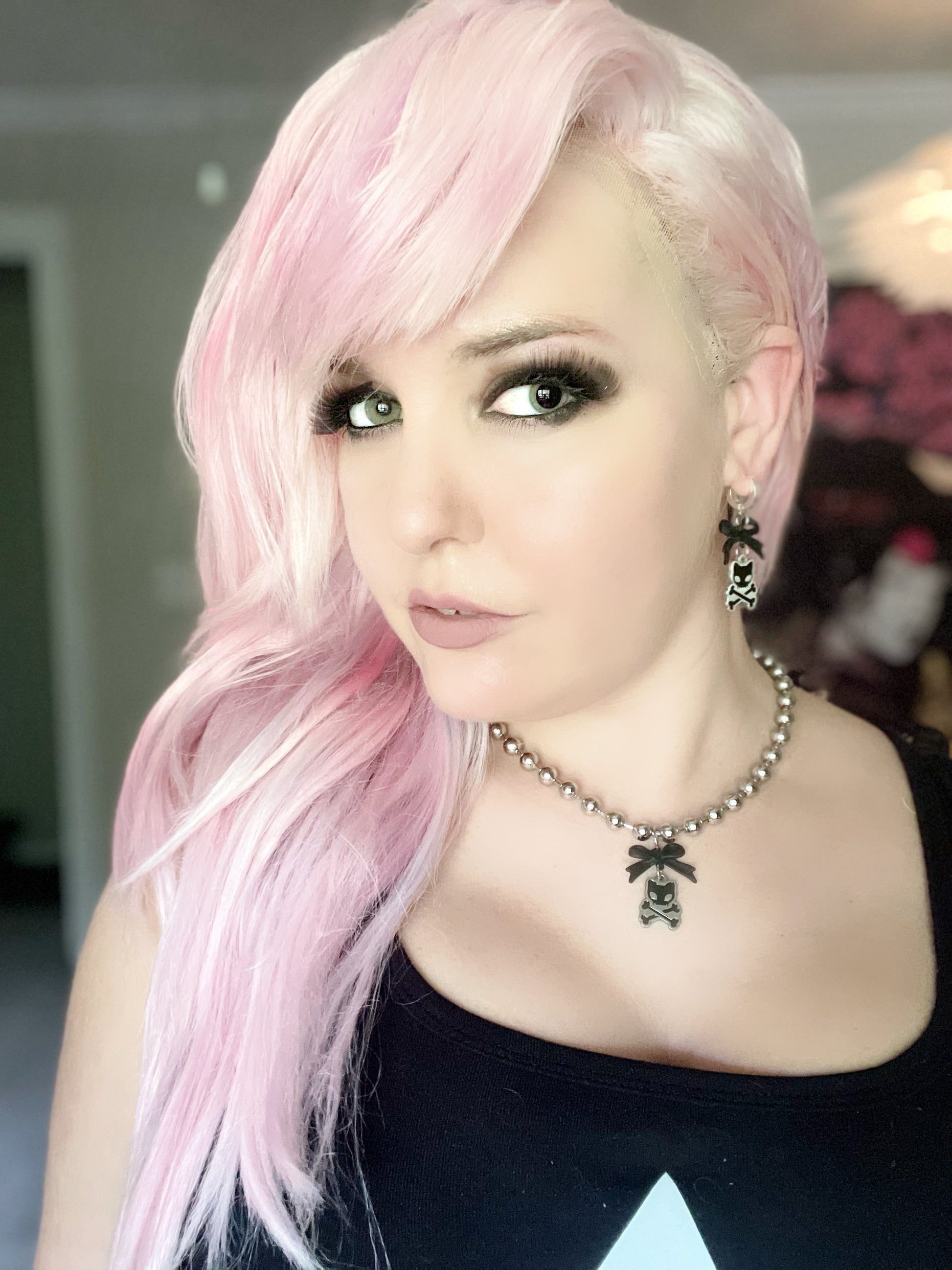 Image shows pink haired white woman wearing the necklace along with other punk jewelry 