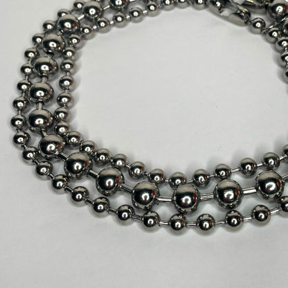 Image shows three layers of ball chain necklaces of varying sizes against a white background 