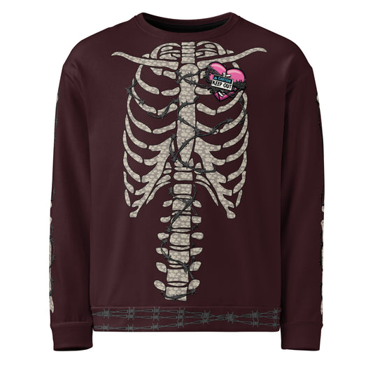 This images shows a wine red sweatshirt with a floral bone-colored ribcage wrapped in barbed wire. There is a hot pink heart on the chest with a sign on it that says “CAUTION: KEEP OUT”. The arms also feature arm bones wrapped in barhed wire and the hem is also wrapped in barbed wire. The caution:Toxic logo is printed as a small label on the upper back of the sweatshirt 